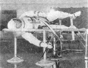 Рис. 45. Имитация невесомости в горизонтальной плоскости. Космонавт М.Коллинз тренируется в пользовании ручной маневровой установкой для передвижения в космосе. Тренажер представляет собой подвеску в раме в тремя опорами на воздушной подушке